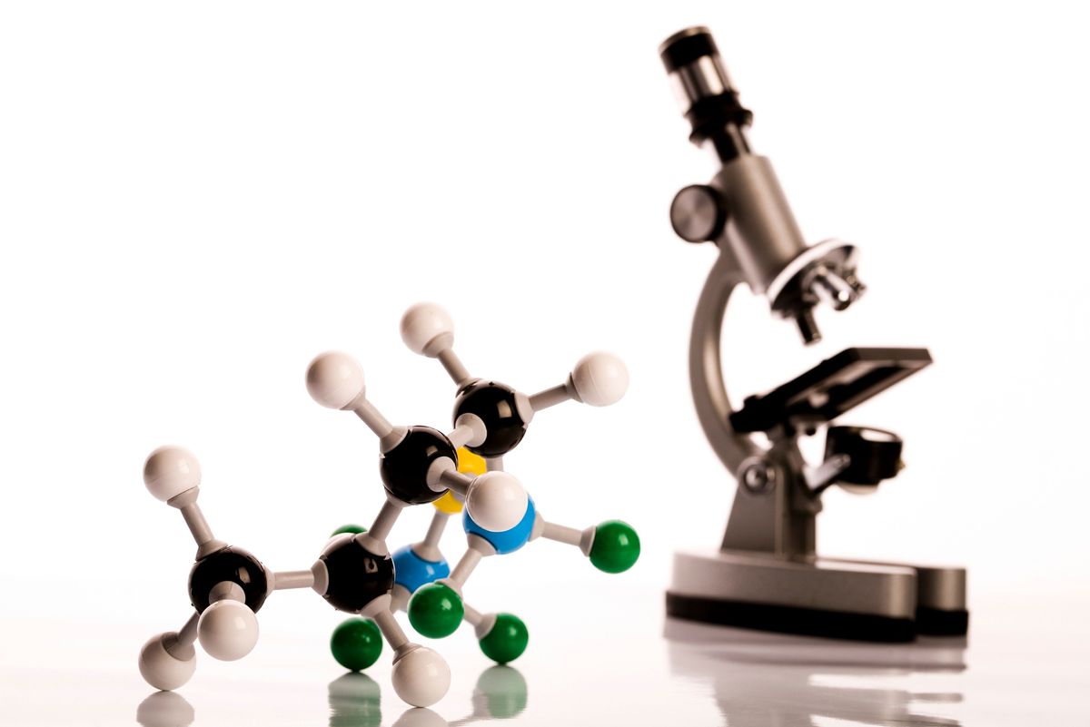 A microscope and a model of a molecule, showcasing the power of atomic force microscopy for surface imaging at atomic resolution.