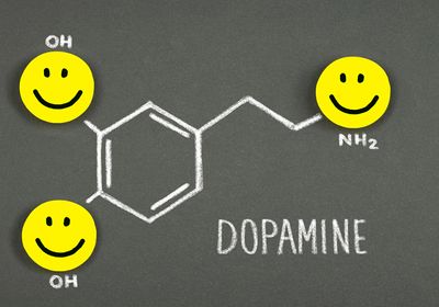 A drawing of a dopamine molecule with happy faces.