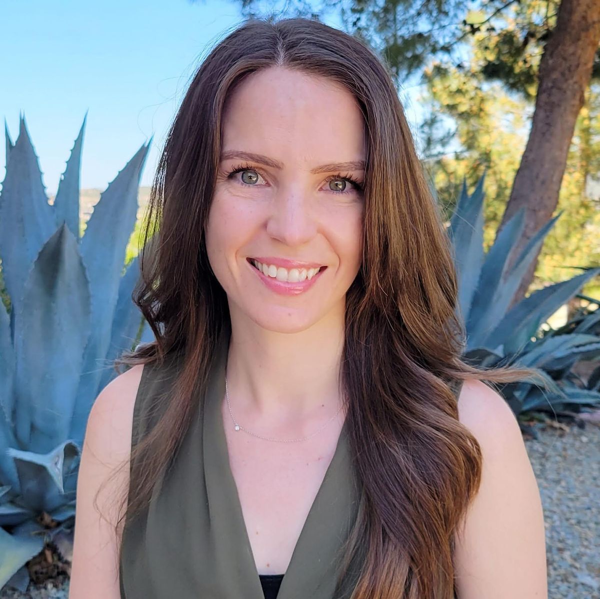 A photograph of woman with brown hair smiling at the camera.