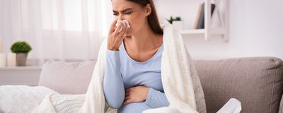 A pregnant woman blowing her nose.