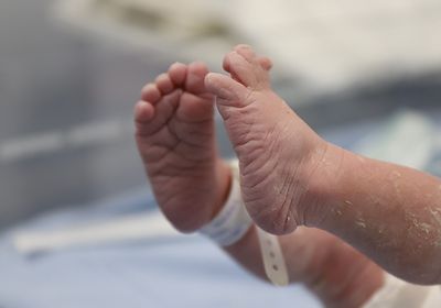 A photo of a newborn baby&rsquo;s feet with a hospital bracelet.