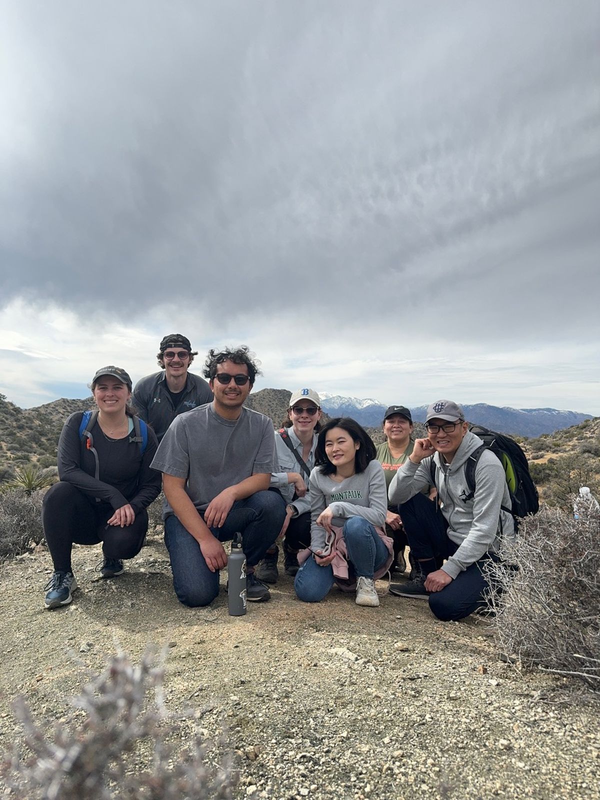 A group of people is surrounded by desert plants. 