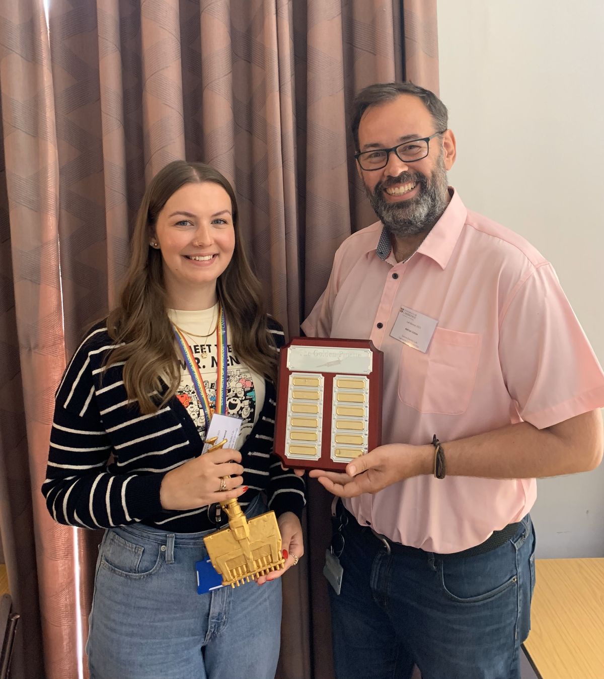 Photo of Amy Dashwood holding a golden multipipette and Adrian Liston holding an award plaque.