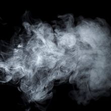 Grey cloud of smoke on a black background.